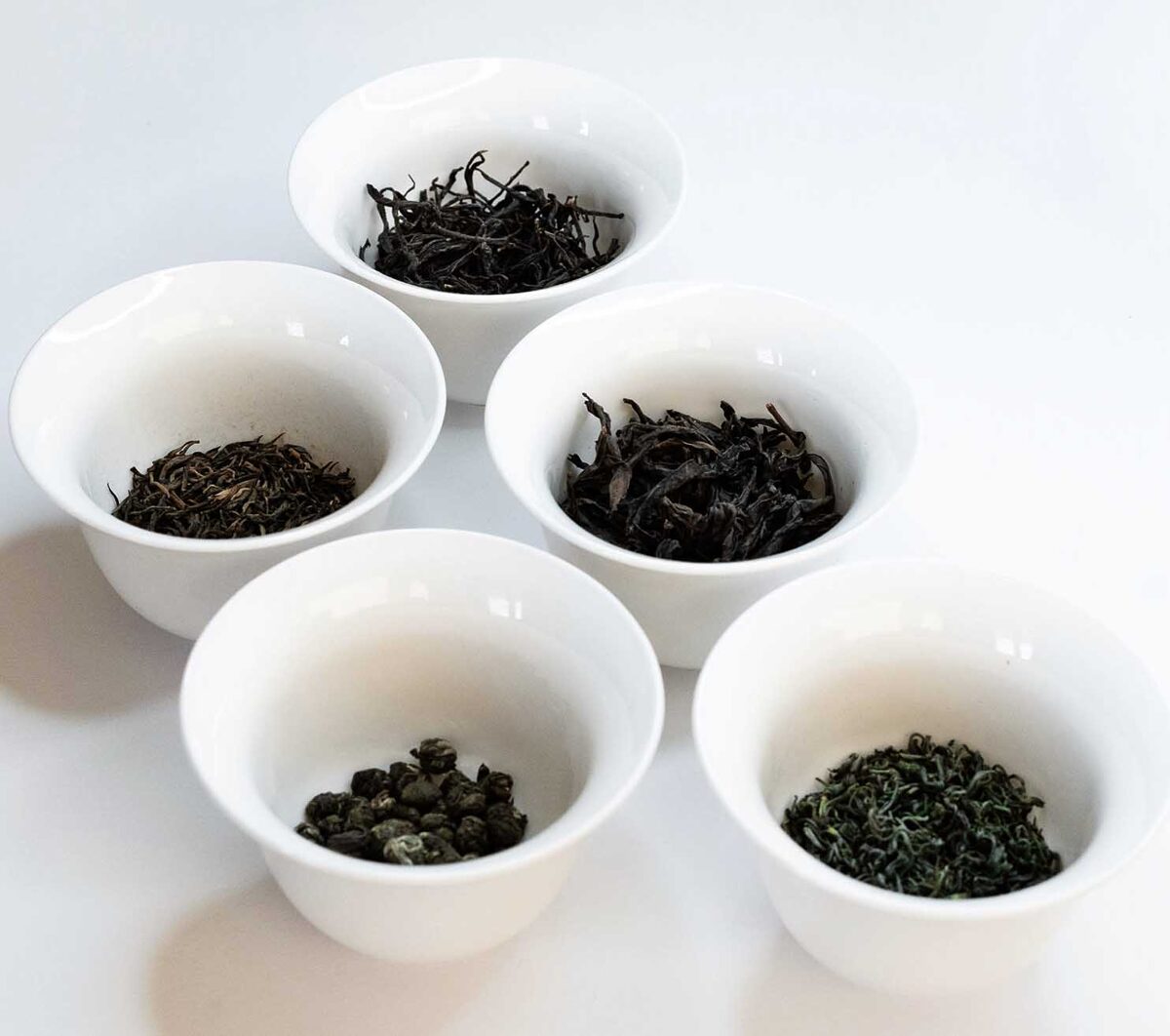 Five white 100 ml gaivans, ech holding 5 g of different tea types for comparisson