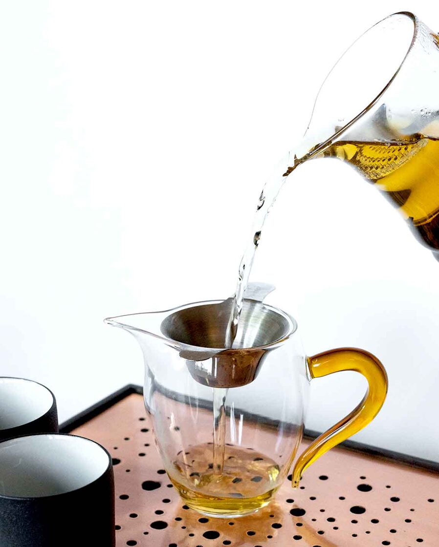Tea is poured in glass fairness cup, western style tea brewing