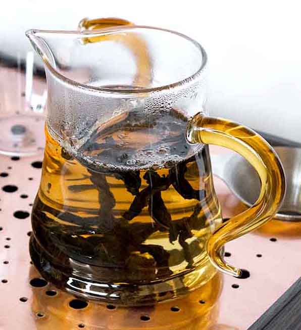Tea infusion in glass teapot, western style tea brewing
