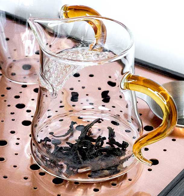 Dry tea leaves in glass teapot, western style tea brewing